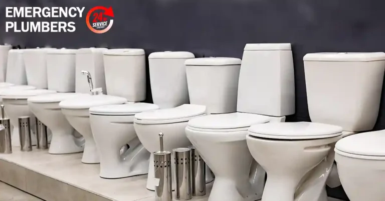 A row of various toilet models display on a showroom floor with a sign that reads "Emergency Plumbers 24/7 Service" in the background.